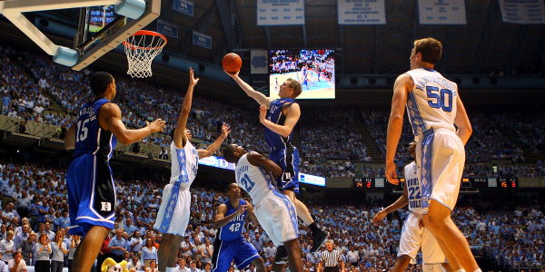 CHAPEL HILL, NC - MARCH 08:  Kyle Singler #12 of the Duke Blue Devils charges over Deon Thompson #21 of the North Carolina Tar Heels during their game at the Dean E. Smith Center on March 8, 2009 in Chapel Hill, North Carolina.  (Photo by Streeter Lecka/Getty Images)